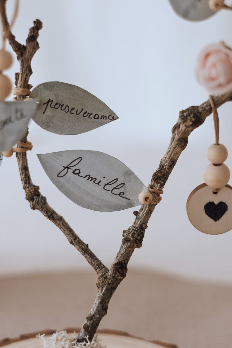 Feuilles « persévérance » et « famille » calligraphiées à la main, et un médaillon en bois en forme de cœur — Entre Deux