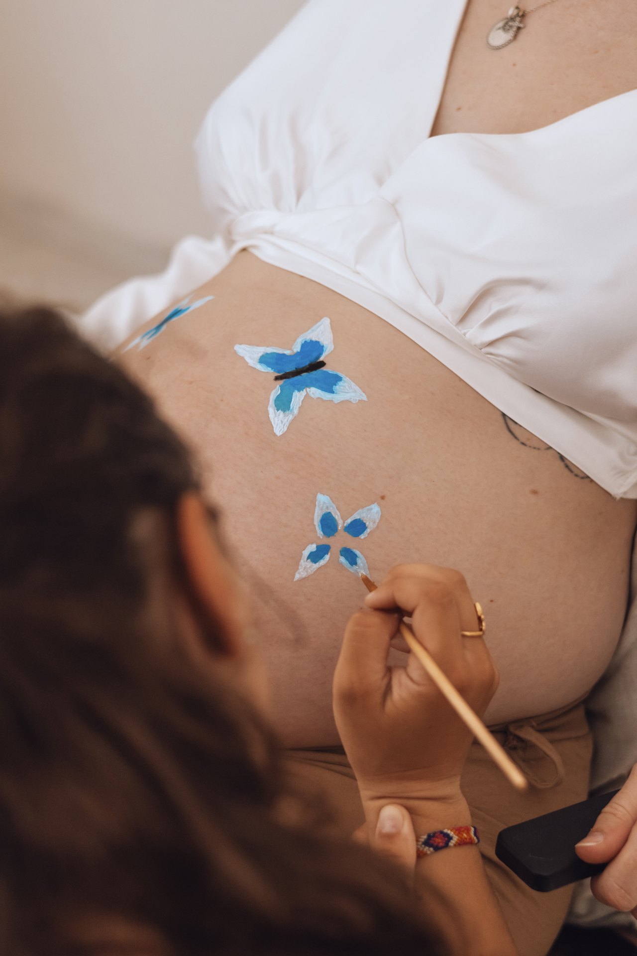 Motif peint au pinceau sur le ventre d'une femme enceinte