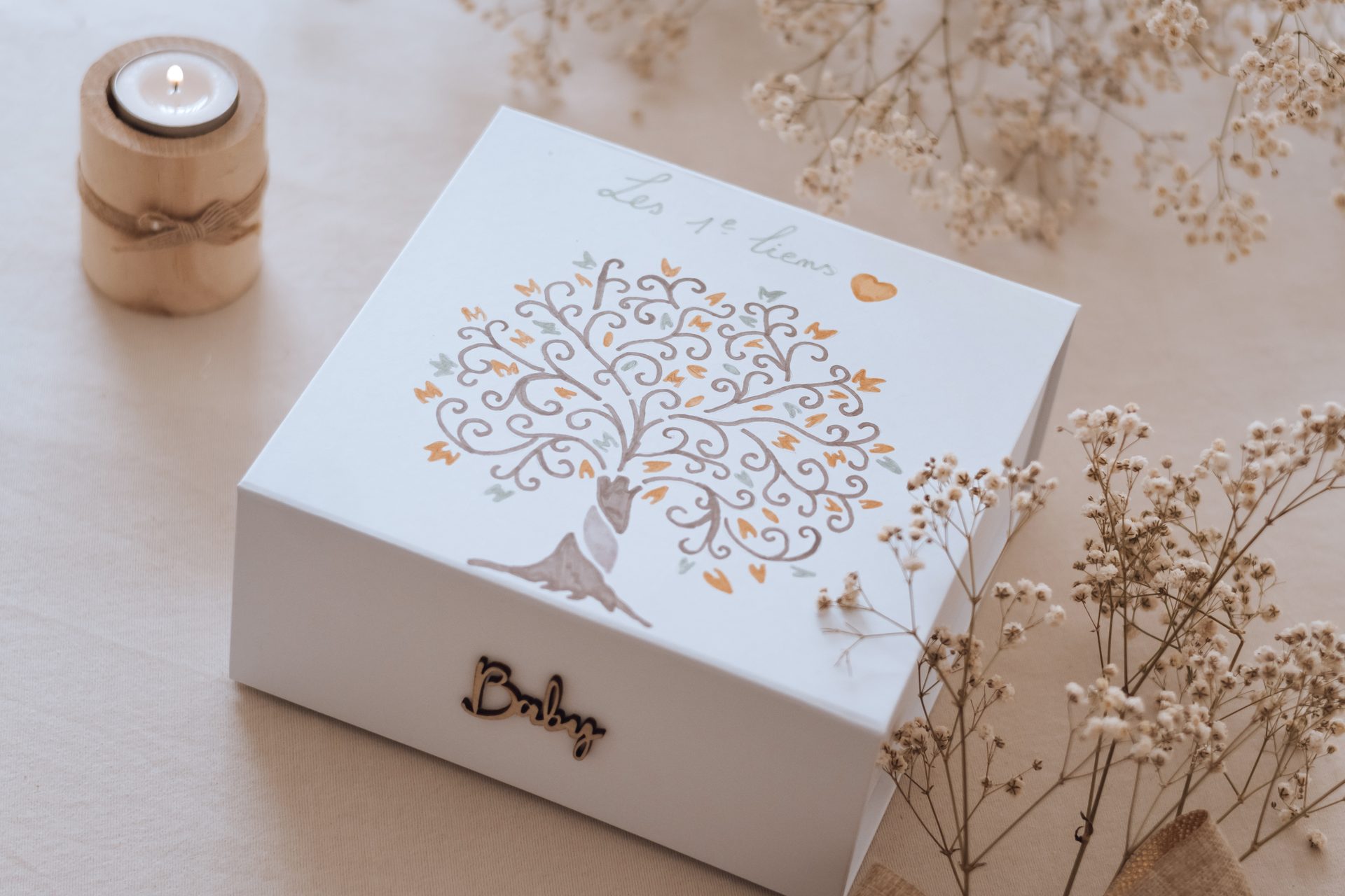 Coffret ouvert garni de ses premiers souvenirs : pochette, cœur en toile et fleurs séchées — Entre Deux