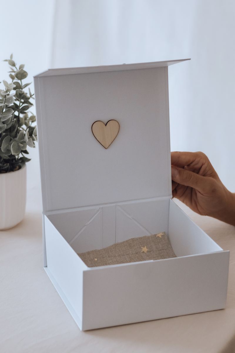 Le coffret ouvert, son cœur de bois sur le couvercle, prêt à recevoir les souvenirs — Entre Deux