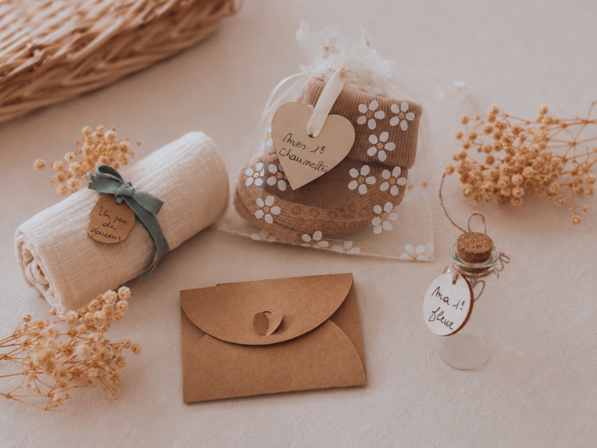 Souvenirs du coffret : lange, chaussettes, fiole et enveloppe prêts à accueillir les premiers liens — Entre Deux