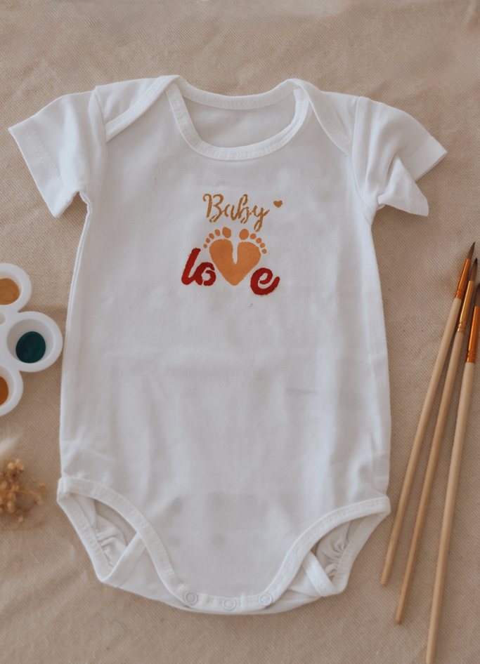 Vêtement « Baby love » peint à la main, aux petits pieds en forme de cœur, avec les pinceaux et la palette — Entre Deux
