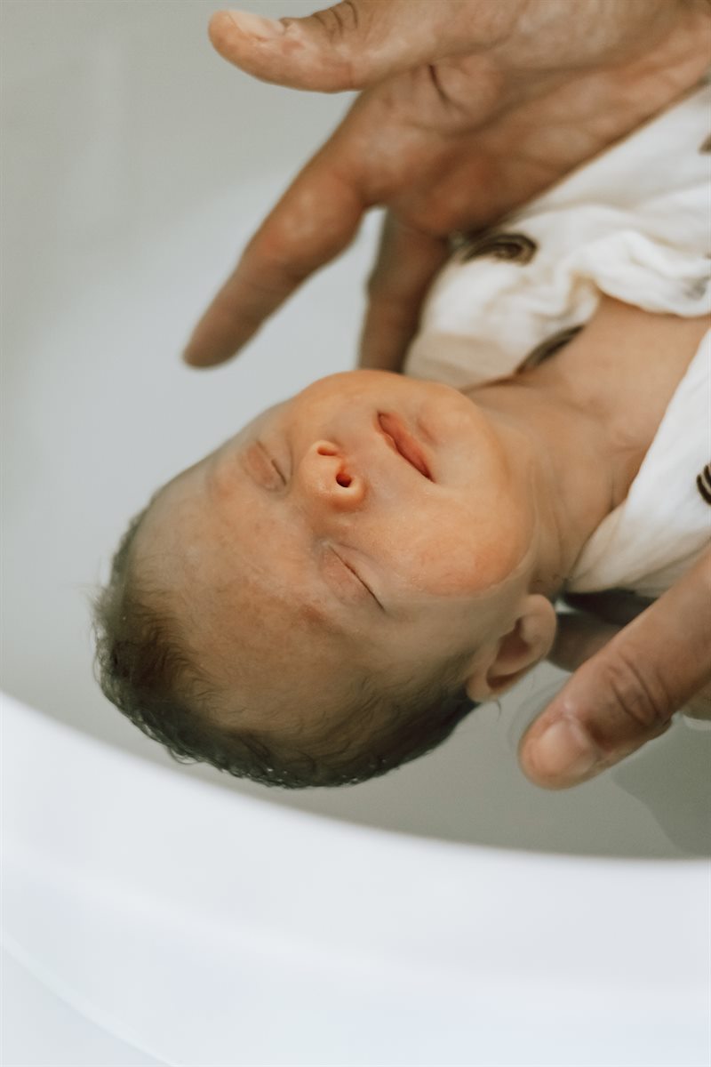 Bébé détendu dans l'eau, tenu par la main de Stéphanie — Entre Deux