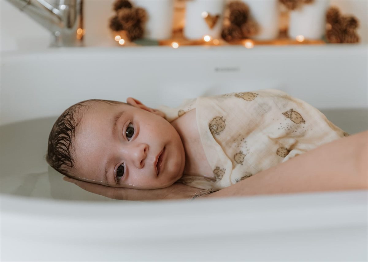 Bébé serein dans l'eau chaude du bain enveloppant — Entre Deux