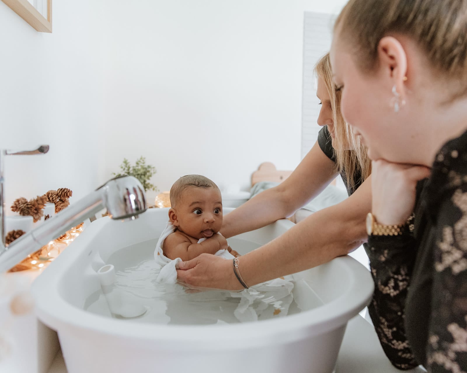 Bébé curieux dans l'eau de son bain enveloppant — Entre Deux