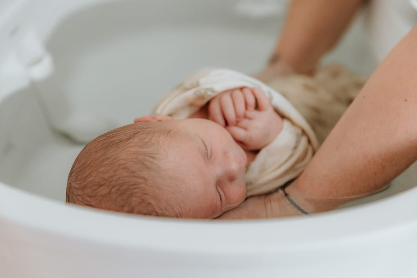 Profil d'un nouveau-né apaisé dans son bain enveloppant — Entre Deux