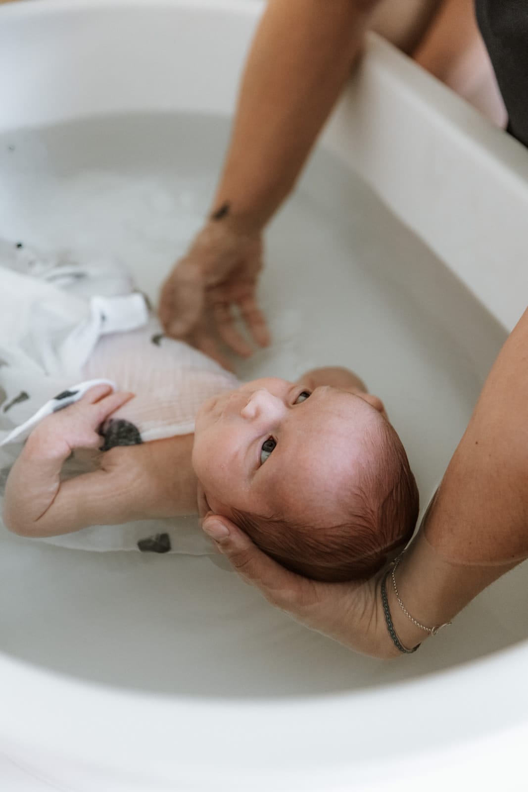 Bébé attentif dans l'eau de son bain enveloppant — Entre Deux